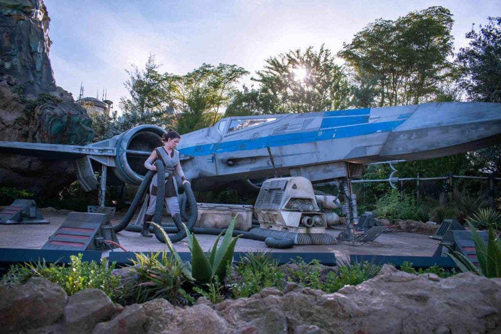 Image of a woman next to a big plane at the Star Wars Galaxy's Edge at Hollywood Studios.